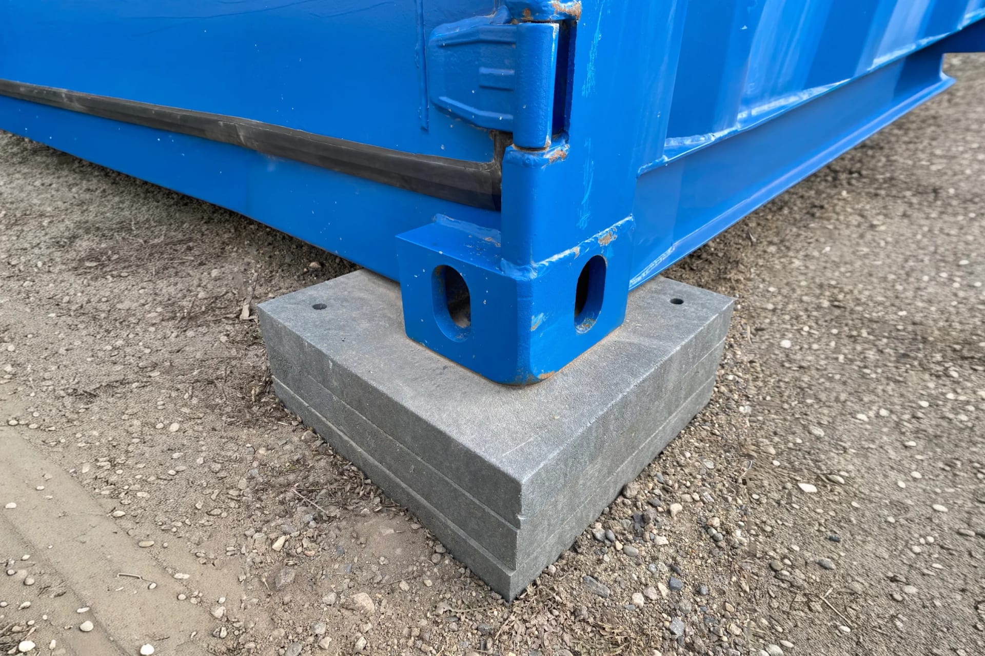 Eckbeschlag eines Seecontainers auf Beton-Ausgleichsplatten